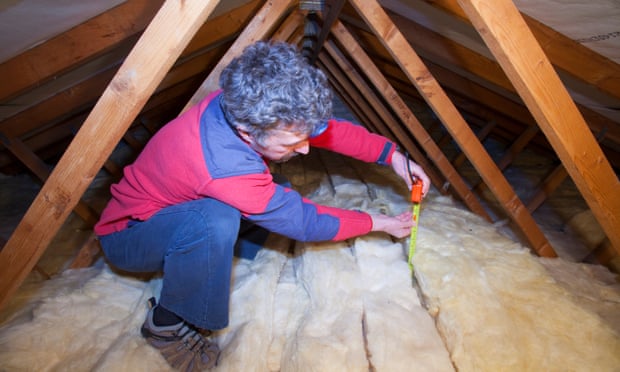 Homeowner measuring loft insulation depth