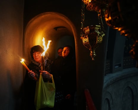 यरूशलेम के पुराने शहर में चर्च ऑफ द होली सेपुलचर में पवित्र अग्नि समारोह के दौरान ईसाई रूढ़िवादी तीर्थयात्री मोमबत्तियाँ पकड़ते हैं