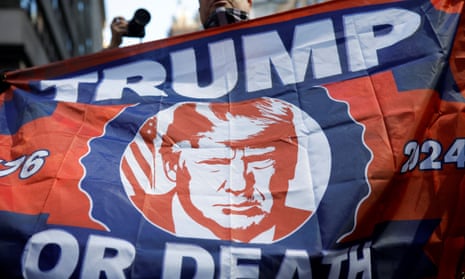 Man holding a red and blue flag reading 'Trump or Death 2024'