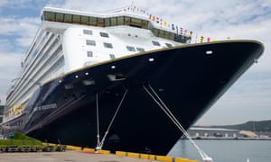 A picture of the front of a large Saga cruise liner with a dark blue hull tied up at a quay.
