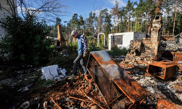 A resident clears the rubble of a house destroyed after shelling near Kyiv, Ukraine