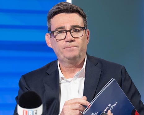 Andy Burnham in front of an LBC microphone holding a copy of the UK defence plan
