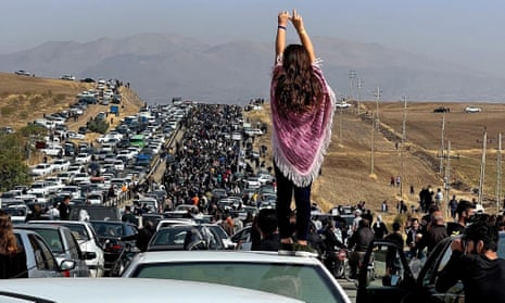 A social media image shows a woman standing on top of a vehicle as thousands protest in Saqez, Mahsa Amini's home town, 40 days after her death.