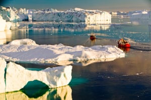 Tourist boat trips sail through icebergs at midnight from the Jacobshavn glacier, Greenland