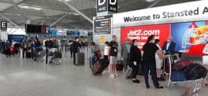 Passengers in queue at Stansted Airport as new quarantine rules for travellers arriving in the UK come into force