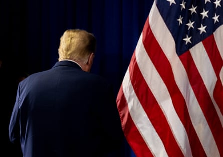 donald trump photographed from behind in front of an american flag