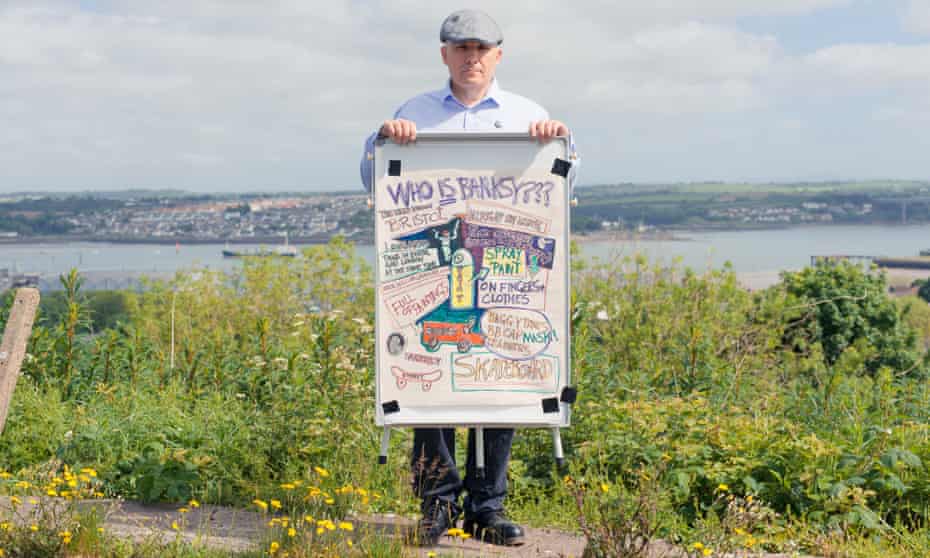 William Gannon with a 'Who is Banksy?' sign