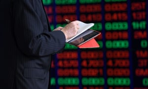 A journalist writes notes in front of the digital market boards at the Australian Stock Exchange (ASX) in Sydney, 13 March 2020.