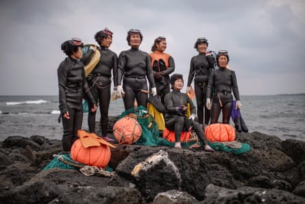 Haenyeo pose in their diving gear on a rock