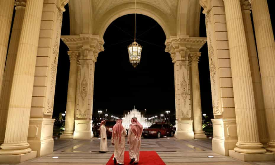 Men walk out of the entrance of the Ritz-Carlton hotel in Riyadh