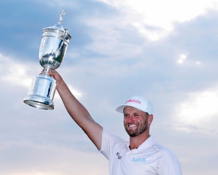 Wyndham Clark holds the championship trophy.