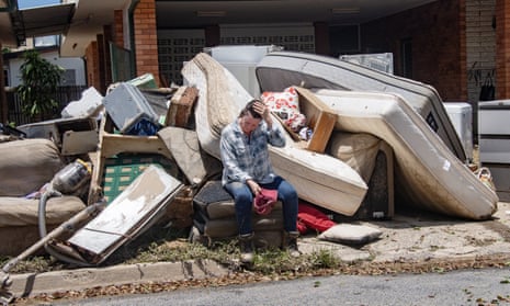 Holloways Beach resident Linda Applbee sits on flood-damaged furniture outside her property