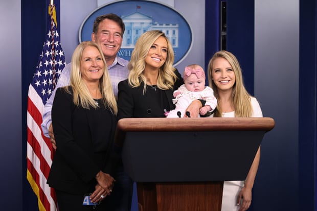 McEnany holds her daughter Blake while posing with her parents Mike and Leanne McEnany and younger sister Ryann McEnany at the podium in the Brady Press Briefing Room.