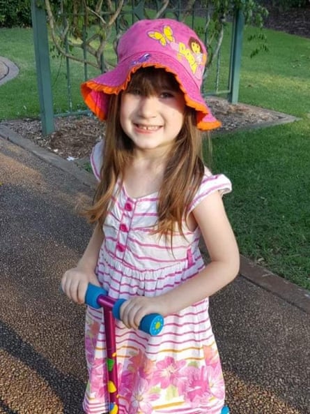 Elizabeth Struhs, smiling, wears a pink floral hat and holds a scooter outdoors