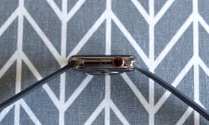 A photo of the Apple Watch Series 6 on its side. It has a button and the digital crown on one side of the watch and speakers on the other.