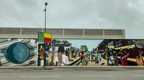 Murals painted along the side of a road in Cotonou.