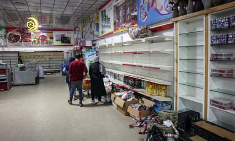 Palestinians in a Khan Yunis supermarket with barely any food left. ‘We have reached a stage where getting bread easily is a victory.’