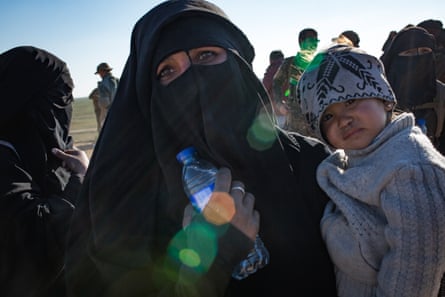 A Ukrainian woman from Crimea seen holding her young boy at a civilian screening point, after fleeing heavy fighting in the city of Baghuz, on 12 February 2019