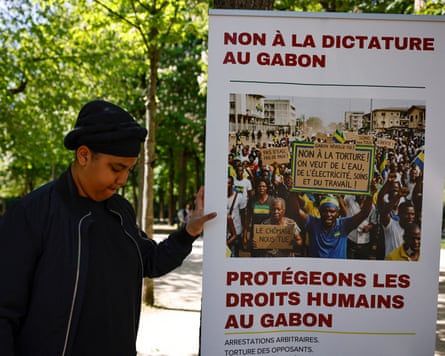 An attendee stands next to a placard reading “no to the dicatorship in Gabon, protect human rights in Gabon” during a demonstration by members of the Gabonese diaspora against the tightening of the regime mear the Gabonese embassy in Paris in April.