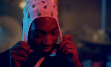 Tinie Tempah puts on an EEG hat, which looks like a weird swimming cap with wires sticking out of it.