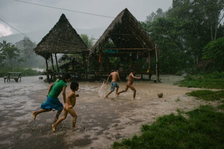 Children play football under torrential rain in Soledad