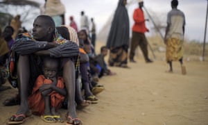 A Somali father sits with his daughter at a registration centre, having been displaced from their home in southern Somalia by famine