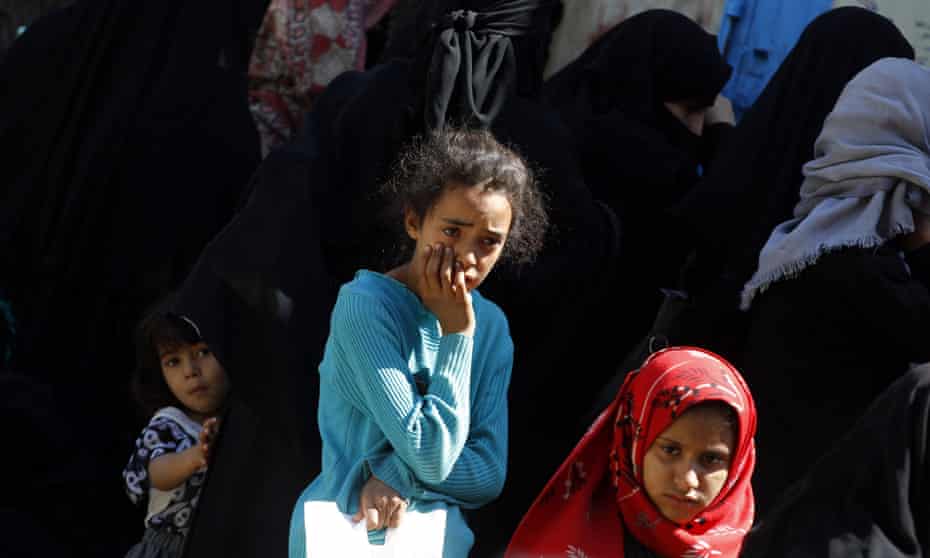 Conflict-affected Yemeni children wait to receive food rations provided by a local charity amid severe food insecurity in Sana’a