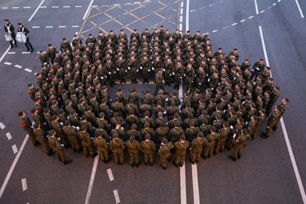 Russian servicemen stand in a circle around an officer who is speaking to them