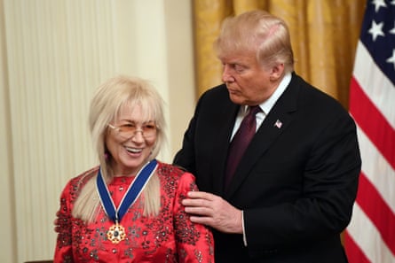 a man looks at a woman after he gave her a medal for some reason