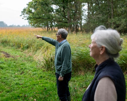 Tim Harris points toward Catfield Fen’s wetland while Geli Harris looks on