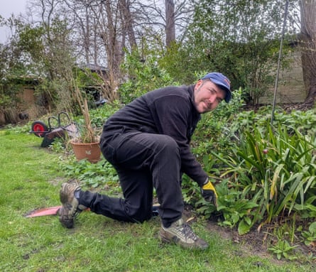 A man kneeling in a garden
