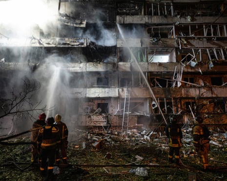Ukrainian firefighters extinguish a blaze at the site of a Russian missile strike at an apartment building in Kyiv.