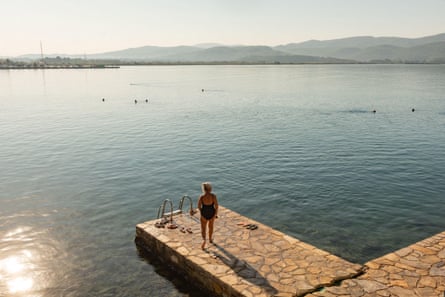 Early-morning bather on a concrete platform/jetty jutting out into the sea