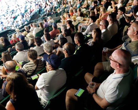 Spectators have phones showing England v the Democratic Republic of the Congo on No 1 Court during Felix Auger-Aliassime’s match against Dino Prizmic