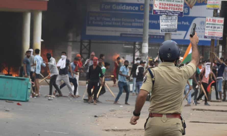 A policeman fires a gun during prA policeman fires a gun during protests in Patna, Bihar