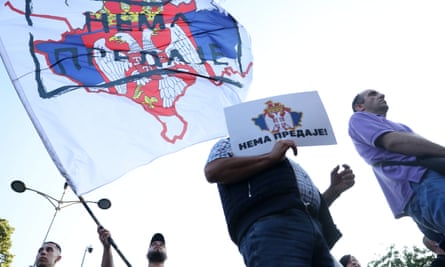 A man waves a flag depicting a map of Kosovo in the colours of the Serbian flag and reading in Serbian ‘No surrender’ during a rally of support for Serbian people in Kosovo, in Belgrade, Serbia, 28 June 2023.