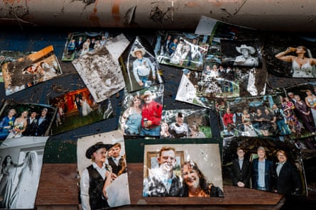Salvaged photographs of a family are displayed on a table in their home after it flooded.