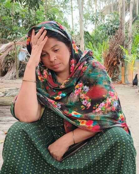 Shahida sits with her head in her hand looking down