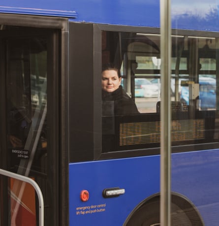 Abi George, a midwife, looking out of the window of a blue bus in Cardiff