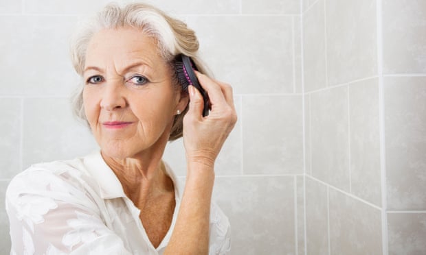 Senior woman brushing hair in bathroom