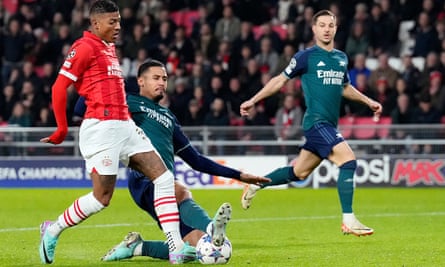 William Saliba (centre) and Patrick van Aanholt (left) during the Champions League match between PSV and Arsenal at the Philips Stadium