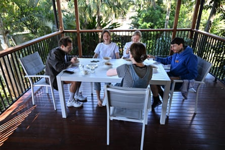 Five people seated around a white table, taste testing a selection of baked beans.