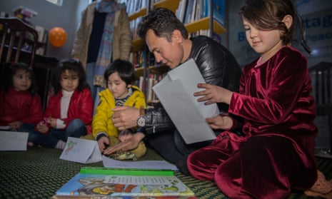 Qanbar Ali Zareh sits with his daughters at a junior book club in Kabul
