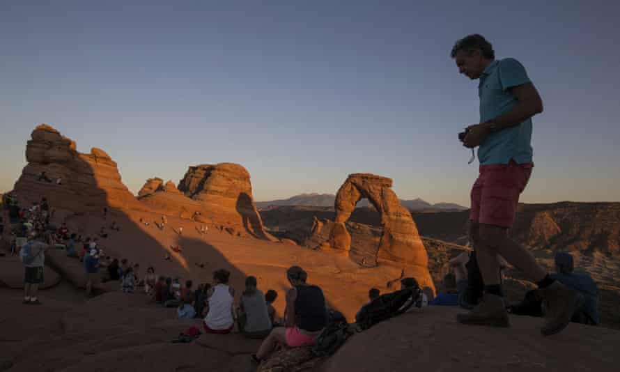 Visitors gather at sunset at Delicate Arch in Arches near Moab, Utah.