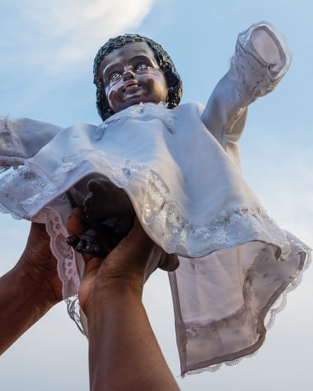 A woman raises the figure of the Black Baby Jesus