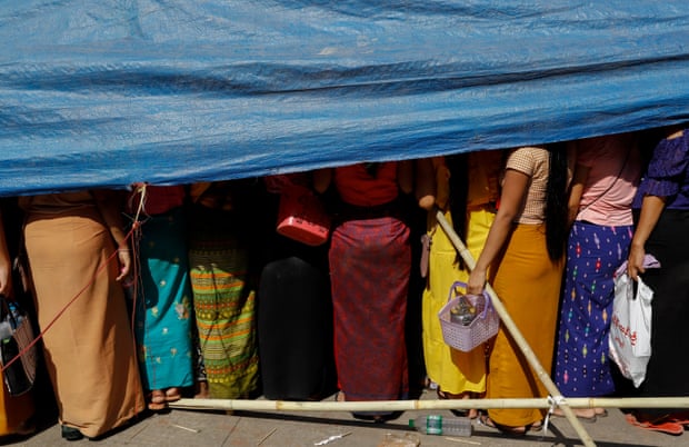 Workers gather under temporary shelter as they demand labor rights outside a garment factory on the outskirts of Yangon, Myanmar, 26 March 2020.