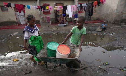 Children fetch water using a wheelbarrow