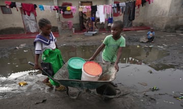 Children fetch water using a wheelbarrow in Lilanda township in Lusaka, Zambia