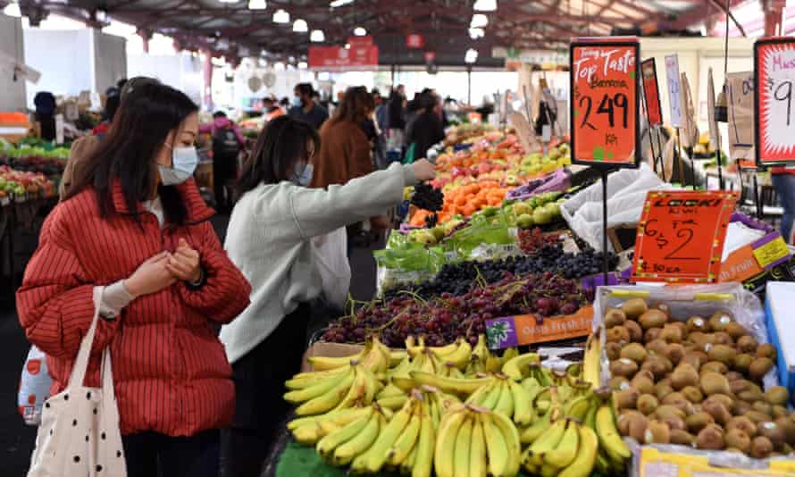 People shop for fruit and vegetables at a market in Melbournes.
