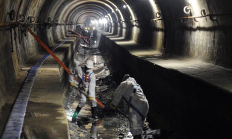 Sewage workers clean a sewer pipe